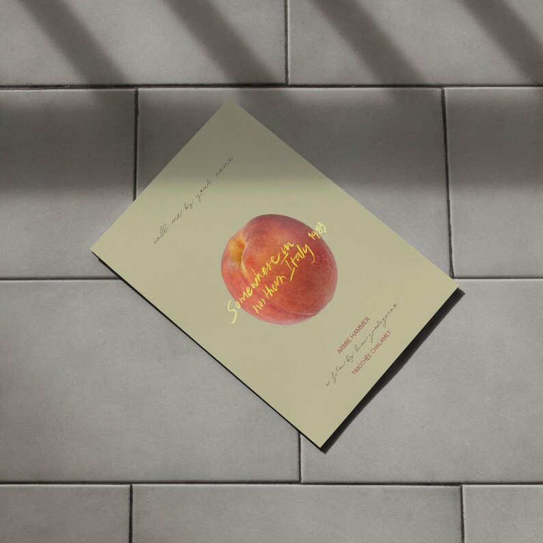 May include: A peach-colored book cover with the title "Somewhere in  between Italy" in gold lettering. The cover features a peach with a single leaf.