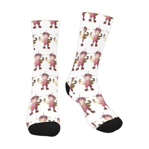 May include: A pair of white socks with a repeating pattern of a pink cartoon character wearing a cape and sunglasses. The socks have black toes and heels.