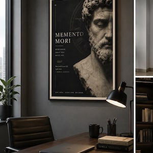 Puede incluir: Un grabado en blanco y negro enmarcado con el texto "MEMENTO MORI" y un busto de un hombre. El grabado cuelga sobre un escritorio de madera con un portátil, libros, una taza negra y una lámpara de escritorio. Una silla de cuero negro está frente al escritorio.