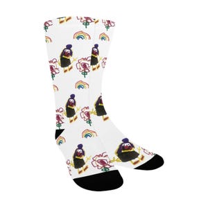 May include: A pair of white socks with a colorful, child-like drawing of a person holding a flower. The drawing is repeated throughout the sock.