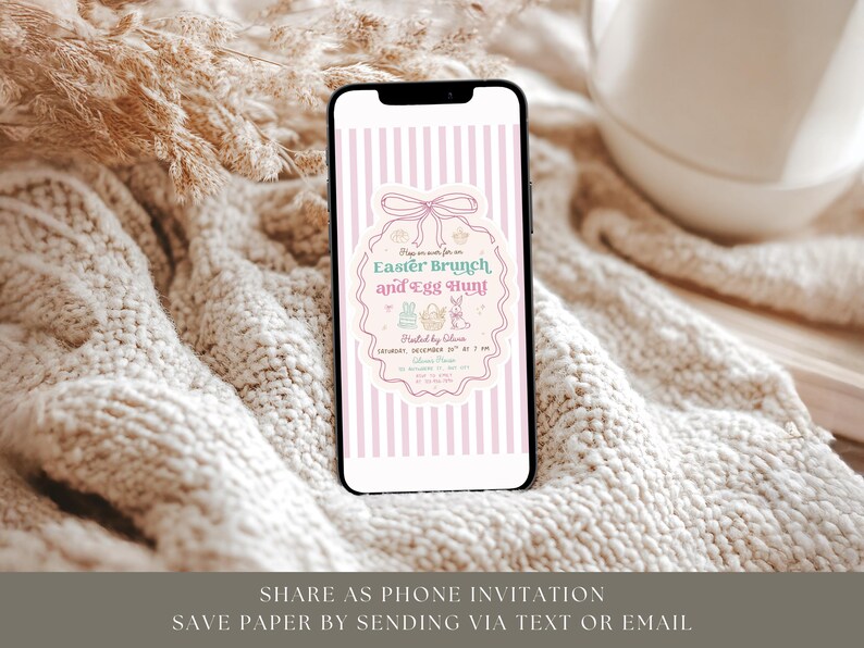 Puede incluir: Un smartphone muestra una invitaci&oacute;n para un brunch de Pascua y una b&uacute;squeda de huevos. La invitaci&oacute;n presenta un fondo a rayas rosas y blancas, un borde decorativo, gr&aacute;ficos en colores pastel y detalles del evento. El tel&eacute;fono est&aacute; sobre una superficie texturizada blanquecina.