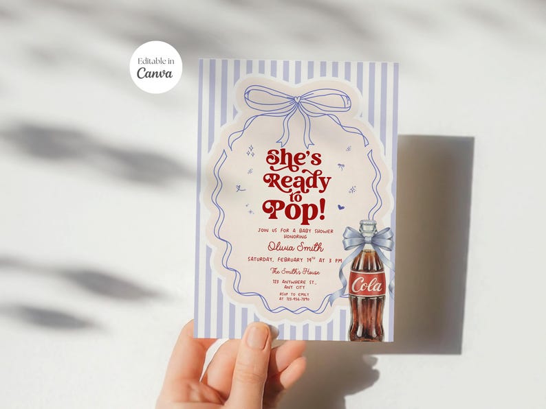 May include: A baby shower invitation with a vintage design. The invitation features the text "She's Ready to Pop!" in red and a drawing of a Coca-Cola bottle. The background has blue and white vertical stripes.