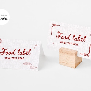 Peut inclure: Deux cartons blancs pour étiquettes alimentaires avec texte et éléments décoratifs rouges. L'un des cartons est soutenu par un petit bloc de bois. Le texte sur les cartons indique "Food label" et "YOUR TEXT HERE".