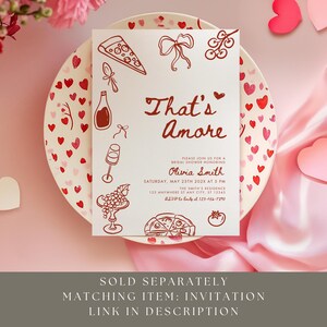 May include: A bridal shower invitation with the text "That's Amore" in a handwritten font, featuring illustrations of pizza, wine, and other Italian food items. The invitation is on a plate decorated with hearts.