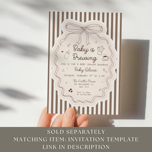K&ouml;nnte beinhalten: Eine Babyparty-Einladung mit dem Text "Baby is Brewing" in einem dekorativen Rahmen. Die Einladung enth&auml;lt Details f&uuml;r die Veranstaltung, wie Datum, Uhrzeit und Ort. Das Design zeigt eine Schleife, eine Kaffeekanne und andere Baby-bezogene Illustrationen.