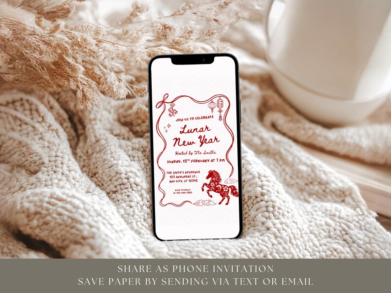 Puede incluir: Un smartphone muestra una invitaci&oacute;n roja y blanca para el A&ntilde;o Nuevo Lunar. El dise&ntilde;o incluye una ilustraci&oacute;n de un caballo, linternas y el texto "Lunar New Year". El tel&eacute;fono descansa sobre una superficie texturizada blanquecina, con una taza blanca en el fondo.