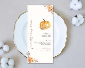 Puede incluir: Una tarjeta de menú rectangular para Friendsgiving con una ilustración de calabaza en acuarela, detalles florales naranjas y texto negro que enumera platos como ensalada de arándanos, sopa de calabaza y pavo asado.