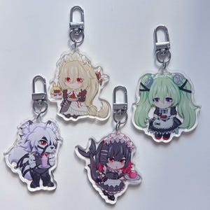 May include: Four anime-style character keychains with silver key rings. The characters are a white wolf-like creature, a girl with black hair and a red bow, a girl with green hair and a white dress, and a girl with blonde hair and a white dress.
