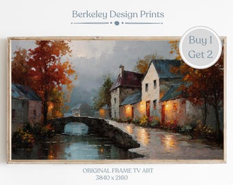 May include: A framed landscape print of a European village scene. The artwork depicts a stone bridge over a river, with buildings and trees in autumn colors. The text "Berkeley Design Prints" and "Buy 1 Get 2" are visible.
