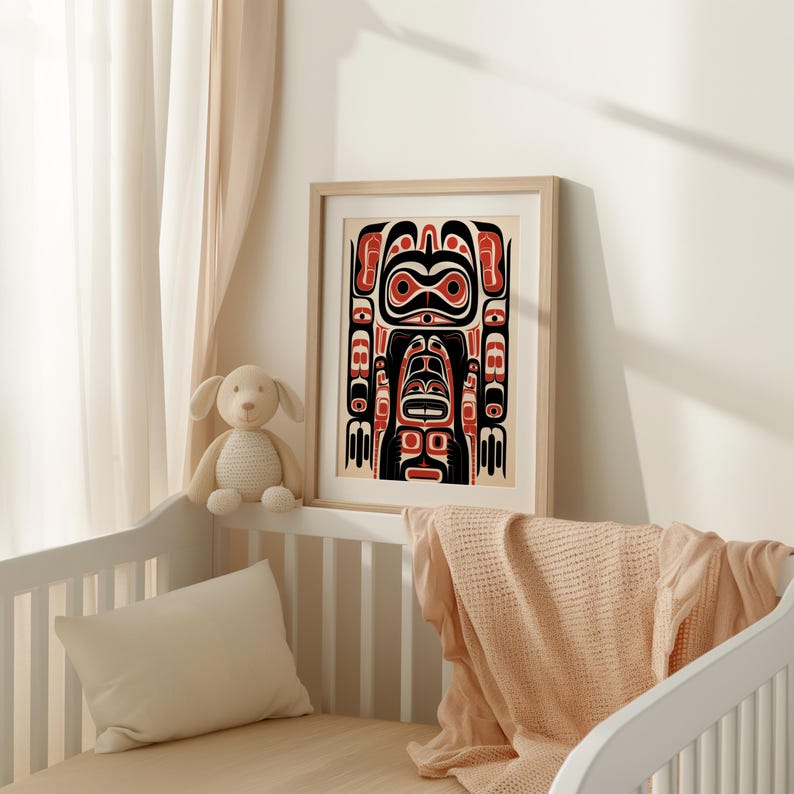 May include: A framed print of a black, red, and white Northwest Coast Indigenous art design. The design features a stylized human figure with geometric patterns.