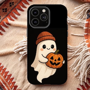 May include: Black phone case featuring a cartoon ghost wearing a brown beanie and holding an orange jack-o'-lantern. The ghost has a friendly expression with rosy cheeks. The case is designed for a smartphone.