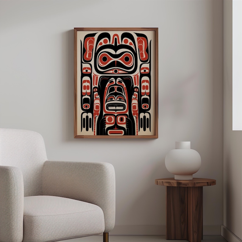 May include: A framed print of a Northwest Coast Indigenous art design featuring a stylized human figure with geometric patterns in black, red, and white.