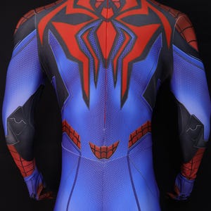 May include: Blue and red superhero costume with a spider-web design. The back of the suit features a large red spider emblem and black accents. The costume is form-fitting and appears to be made of a flexible material.