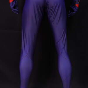 May include: A form-fitting, purple jumpsuit with red and blue accents on the arms and gloves. The suit has a streamlined design with textured panels on the legs. The overall aesthetic suggests a superhero or futuristic theme.