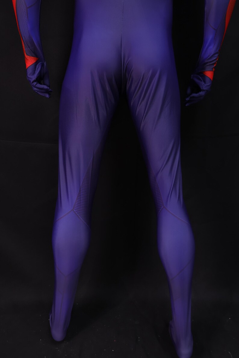 May include: A form-fitting, purple jumpsuit with red and blue accents on the arms and gloves. The suit has a streamlined design with textured panels on the legs. The overall aesthetic suggests a superhero or futuristic theme.