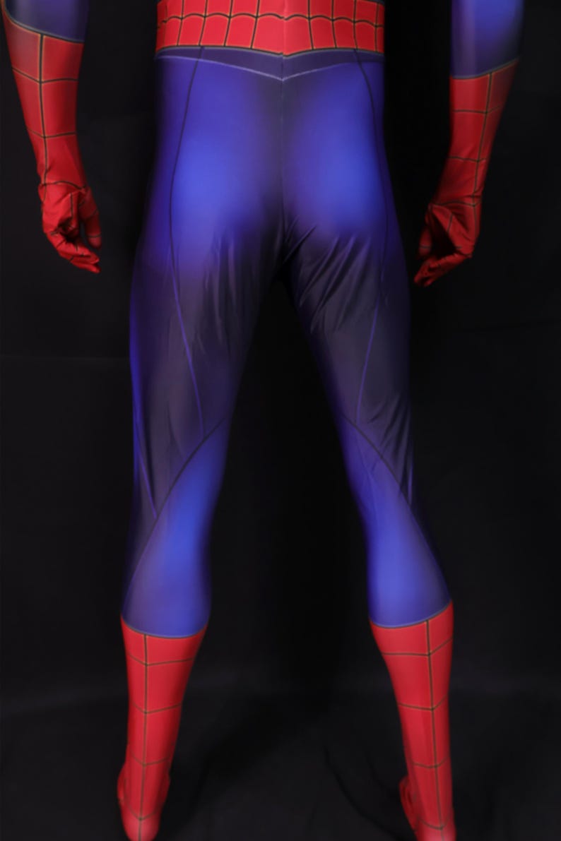 Puede incluir: Un disfraz de superh&eacute;roe azul y rojo. El disfraz tiene un cuerpo azul con detalles rojos en los guantes, las botas y la parte superior del pecho. Las secciones rojas tienen un patr&oacute;n de telara&ntilde;a.