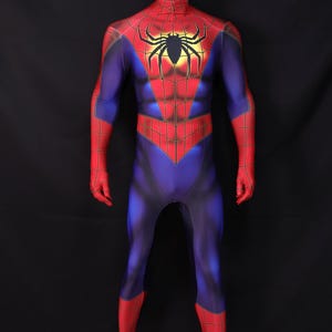 Puede incluir: Un disfraz completo de Spider-Man en un maniqu&iacute;. El disfraz es principalmente azul con detalles en rojo en los brazos, manos y piernas. Un gran emblema de ara&ntilde;a negra est&aacute; centrado en el pecho, con un dise&ntilde;o de telara&ntilde;a roja y amarilla.