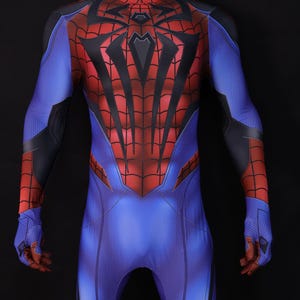May include: A full-body superhero costume in blue, red, and black. The suit features a web-like design on the red areas, with a spider emblem on the chest. The costume is displayed on a mannequin against a black background.