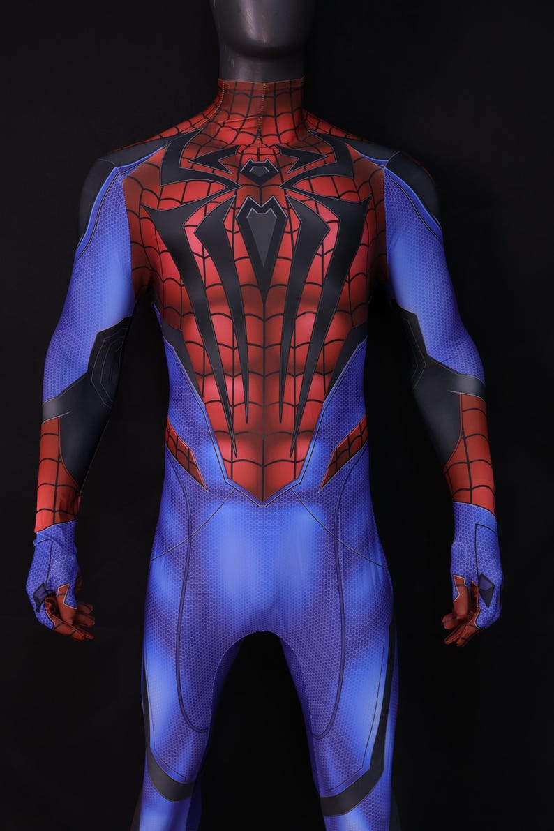 May include: A full-body superhero costume in blue, red, and black. The suit features a web-like design on the red areas, with a spider emblem on the chest. The costume is displayed on a mannequin against a black background.