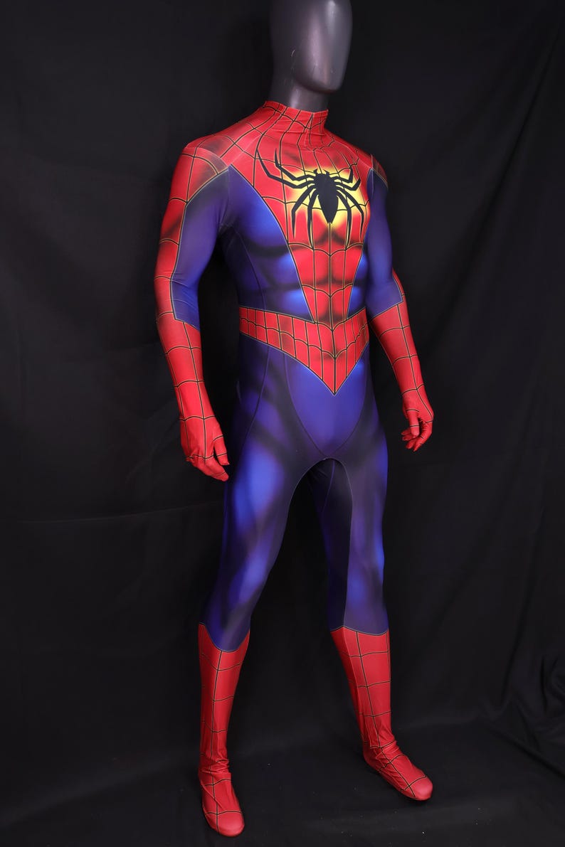 Puede incluir: Un disfraz de Spider-Man de cuerpo entero sobre un maniqu&iacute;. El disfraz es principalmente azul con detalles en rojo en los brazos, manos y piernas. Un gran emblema de ara&ntilde;a negra est&aacute; en el pecho.
