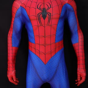May include: A red and blue superhero costume with a spiderweb design and a black spider emblem on the chest. The all-in-one suit has a high collar and covers the entire body, including the hands.
