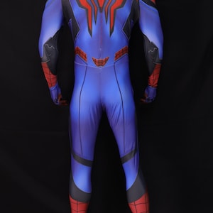 May include: Blue and red superhero costume with a spider-themed design. The full-body suit features a blue base with red accents on the arms, legs, and back. A large red spider emblem is on the back.