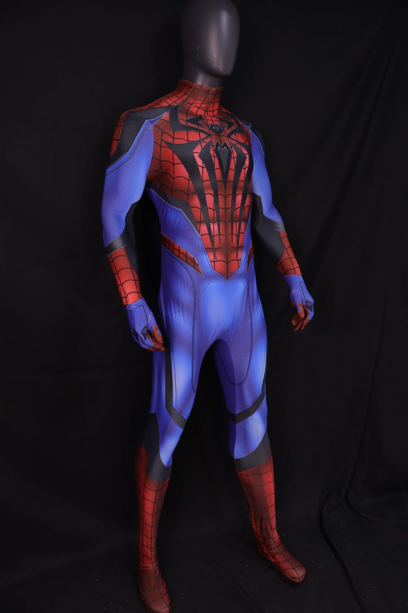 May include: A full-body superhero costume in blue, red, and black, displayed on a mannequin. The costume features a spiderweb design on the chest and a mask that covers the entire head. The suit has a form-fitting design.