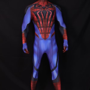 May include: A full-body Spider-Man costume on a mannequin. The suit is primarily blue with red accents on the chest, arms, and legs. Black webbing details and a spider emblem are visible on the chest.
