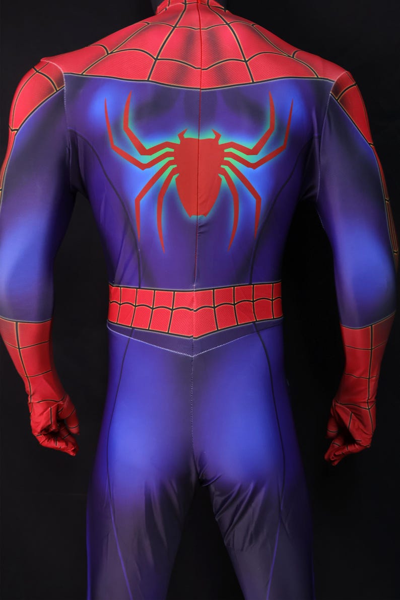 Puede incluir: Un disfraz de superh&eacute;roe azul y rojo con un gran emblema de ara&ntilde;a roja en la espalda. El disfraz presenta un dise&ntilde;o de telara&ntilde;a roja en los hombros y la cintura, con guantes rojos y una capucha roja.