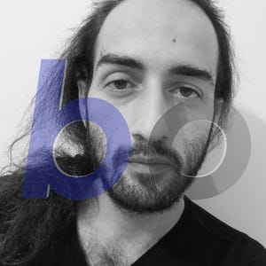 May include: A black and white portrait of a person with long dark hair and a beard, wearing a black v-neck shirt. A large, semi-transparent blue letter b and a grey letter o are superimposed over the face and hair, partially obscuring the features.