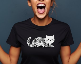 Peut inclure: Un t-shirt noir avec un motif de chat blanc. Le chat est composé du mot "chat" dans plusieurs langues, notamment "el gato", "il gatto", "le chat", "der kater", "de kat", "o gato", "kot", et "neko".