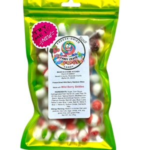 Può includere: Un sacchetto verde richiudibile pieno di caramelle acide liofilizzate. Le caramelle hanno la forma di piccole sfere e sono rosse, bianche, verdi e blu. Il sacchetto ha un'etichetta che dice "Candy Crave" e "Freeze-Dried Sour". L'etichetta elenca anche gli ingredienti e le informazioni sulle allergie. Il sacchetto è etichettato con "Try Me! New!"
