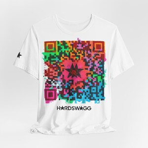 Op de afbeelding: Wit T-shirt met een kleurrijk QR-code ontwerp met een bloemmotief in het midden. Het ontwerp bevat verschillende kleuren, waaronder roze, groen en oranje. De tekst "HARDSWAGG" is onderaan het ontwerp gedrukt. Een zwarte ster is op de linkermouw gedrukt.