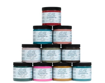 May include: A pyramid display of ten 8-ounce jars of all-in-one mineral paint in various colors, including fiery sky, oasis, desert rose, cactus, ember, midnight green, prickly pear, olive, and morace. The jars are labeled with the brand name "Silk".