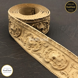 May include: A roll of beige wood trim with an ornate floral and scroll design. The trim is labeled "WoodUbend" and "Spring 2022 New Release". The design is a 3rd generation improved design.