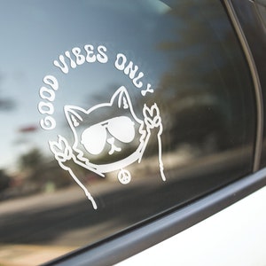 May include: White vinyl sticker with a cartoon cat wearing sunglasses and peace signs, with the text "Good Vibes Only" around the cat.