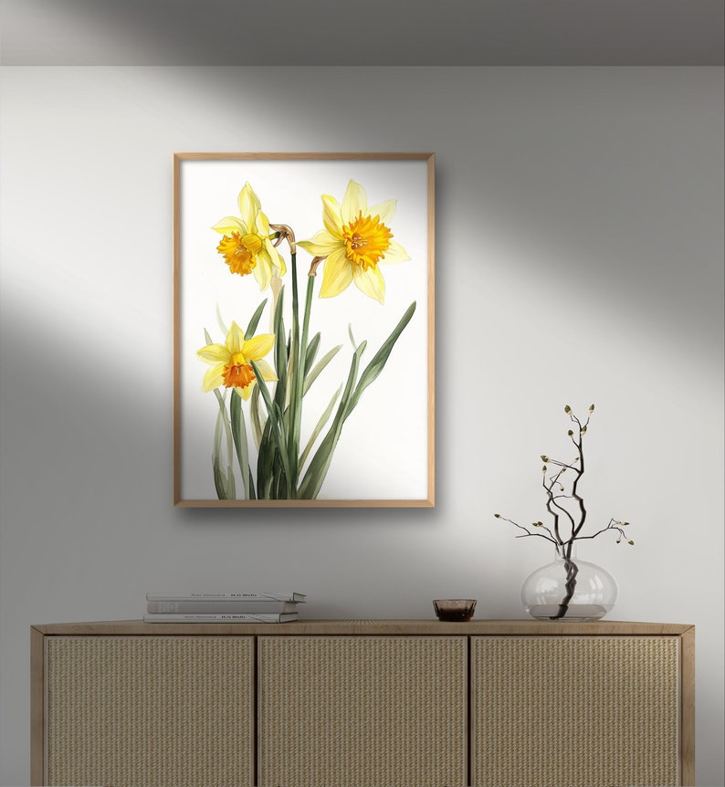 May include: A framed watercolor painting of three yellow daffodils with orange centers on a white background.