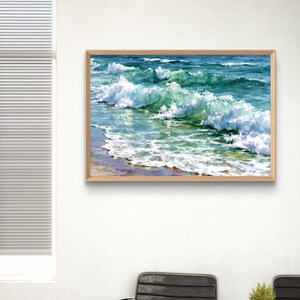 May include: A rectangular framed wall art print featuring a vibrant watercolour painting of ocean waves crashing onto a sandy shore. The artwork displays shades of deep blue, turquoise, and white sea foam, captured in a light-coloured wooden frame.