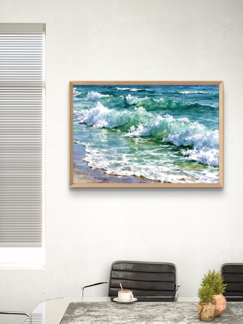 May include: A rectangular framed wall art print featuring a vibrant watercolour painting of ocean waves crashing onto a sandy shore. The artwork displays shades of deep blue, turquoise, and white sea foam, captured in a light-coloured wooden frame.