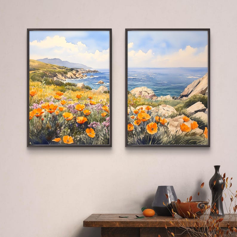 May include: Two framed watercolor paintings depicting a coastal landscape with orange wildflowers in the foreground and a blue ocean in the background.