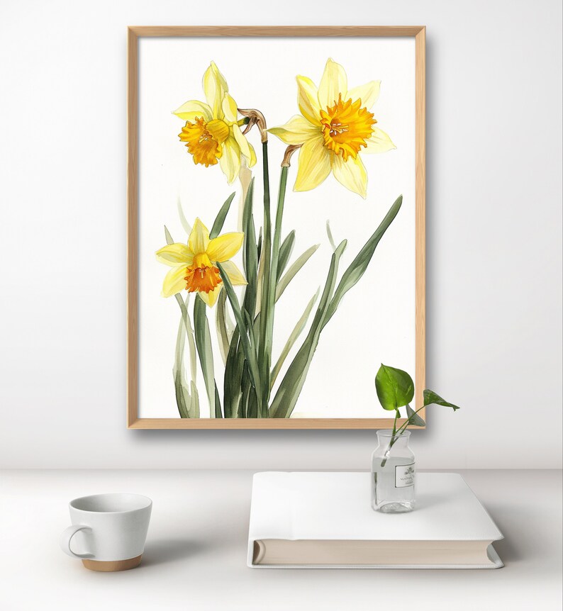 May include: A framed watercolor painting of three yellow daffodils with orange centers. The flowers are depicted with green leaves against a white background.