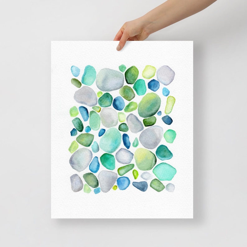 Puede incluir: Impresi&oacute;n en acuarela con un dise&ntilde;o abstracto de formas redondeadas en tonos azules, verdes y grises. La obra de arte tiene un aspecto suave y texturizado, con las formas dispuestas en un patr&oacute;n disperso sobre un fondo blanco.