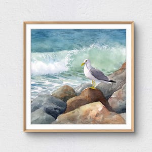 May include: Watercolor painting of a seagull perched on rocks at the edge of the ocean. The bird has gray and white feathers, a yellow beak and yellow legs. The background shows a crashing wave and blue water.