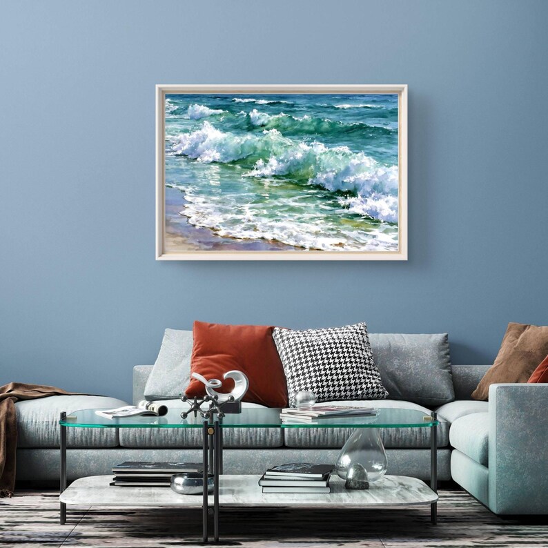 May include: A rectangular wall art print featuring a realistic painting of ocean waves crashing towards a sandy shore. The artwork displays shades of deep blue, turquoise, and white sea foam, enclosed within a simple light-coloured wooden frame.
