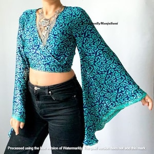 May include: A blue and green patterned wrap top with long, wide bell sleeves. The top is cropped and has a V-neckline.