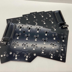 Peut inclure: Gros plan sur un circuit imprimé noir avec plusieurs rangées de petites LED blanches rondes. La carte est conçue pour un clavier.