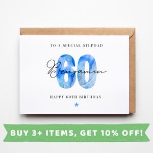 May include: A white card with a blue and gold watercolour design of the number 60. The text "To a special stepdad" and "Happy 60th Birthday" is printed in black. The name "Benjamin" is written in cursive.