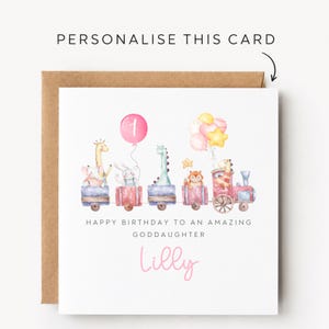 May include: A square white birthday card featuring a watercolor illustration of a train carrying an elephant, giraffe, rabbit, dinosaur, and fox. Balloons float above the train. Text reads: PERSONALISE THIS CARD, HAPPY BIRTHDAY TO AN AMAZING GODDAUGHTER, and Lilly.