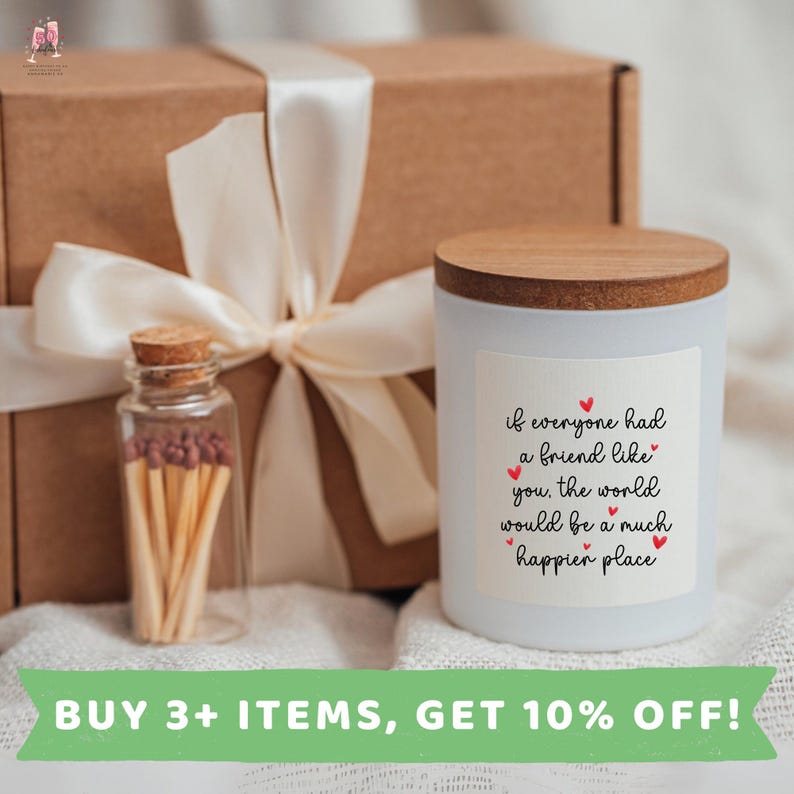 May include: A white candle with a wooden lid and a label that reads "if everyone had a friend like you, the world would be a much happier place". The candle is sitting on a brown box wrapped in white ribbon. A small glass jar filled with matches is next to the candle.
