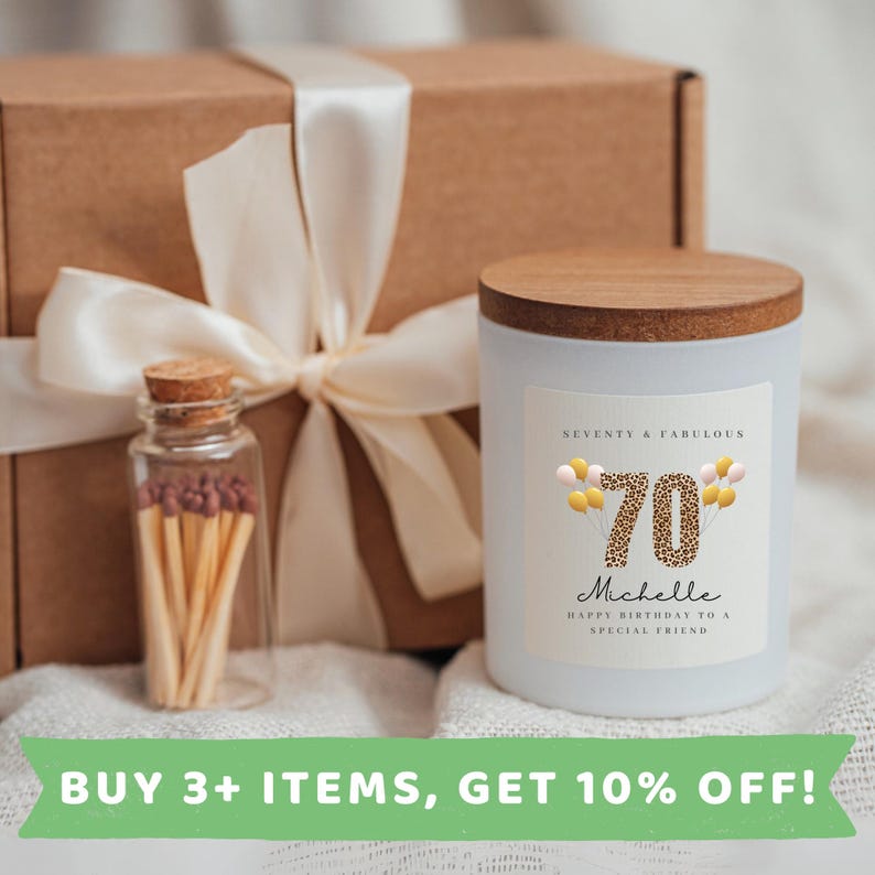 May include: A white candle with a brown wooden lid and a label that says "Seventy & Fabulous 70 Michelle Happy Birthday to a Special Friend". The candle is packaged in a brown box with a white ribbon.